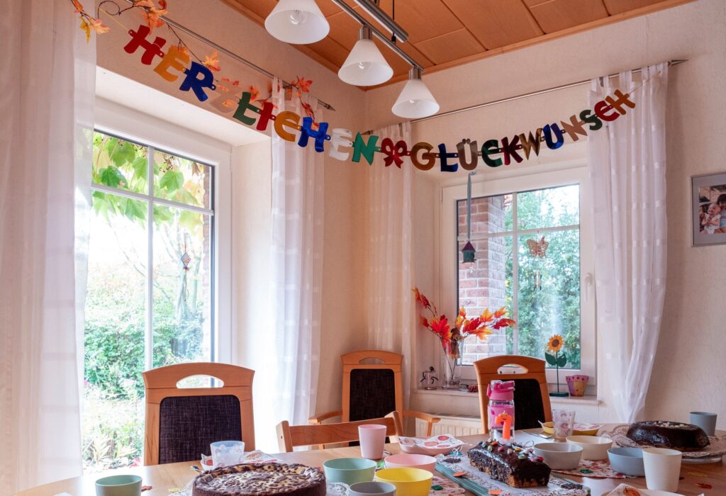 Festive indoor celebration table with cakes and colorful decorations for a joyous occasion.